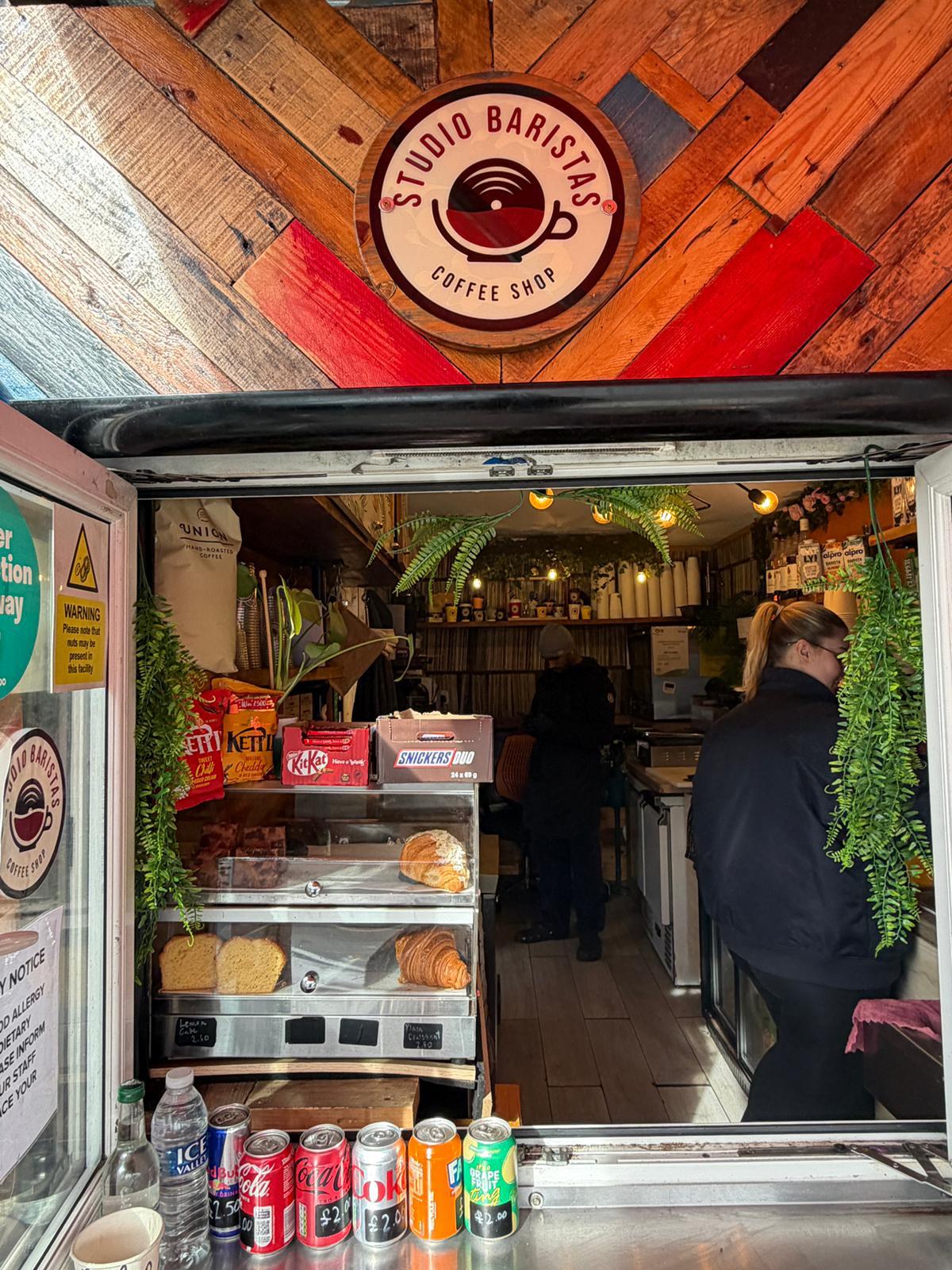 The Studio Baristas shopfront with reclaimed wood and logo sign